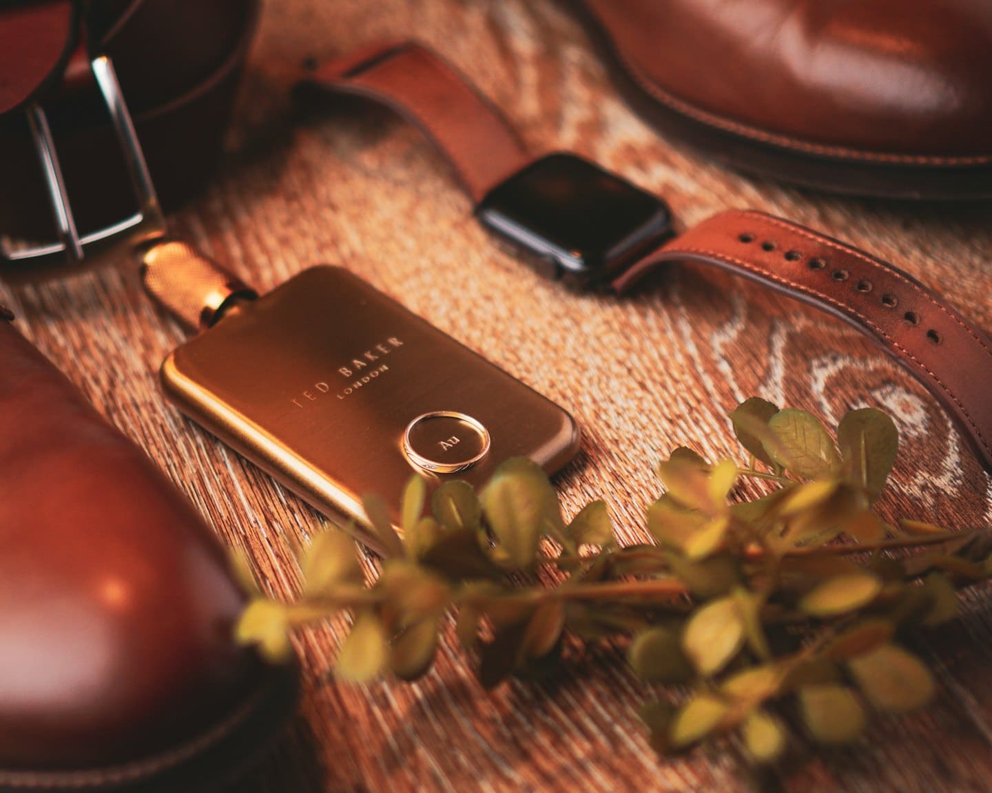 Men's accessories including leather shoes, a watch, and cologne.